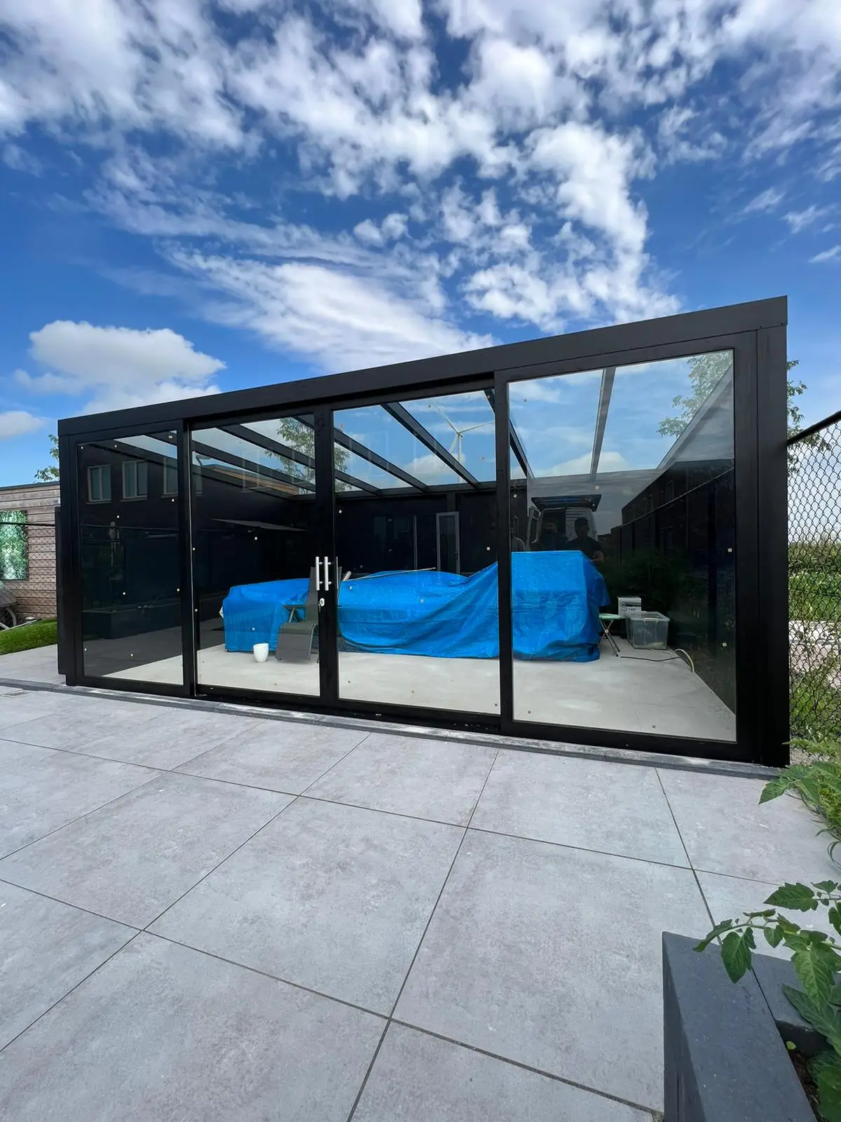 Veranda mit Glasdach und blickdichter Plane während Umbau