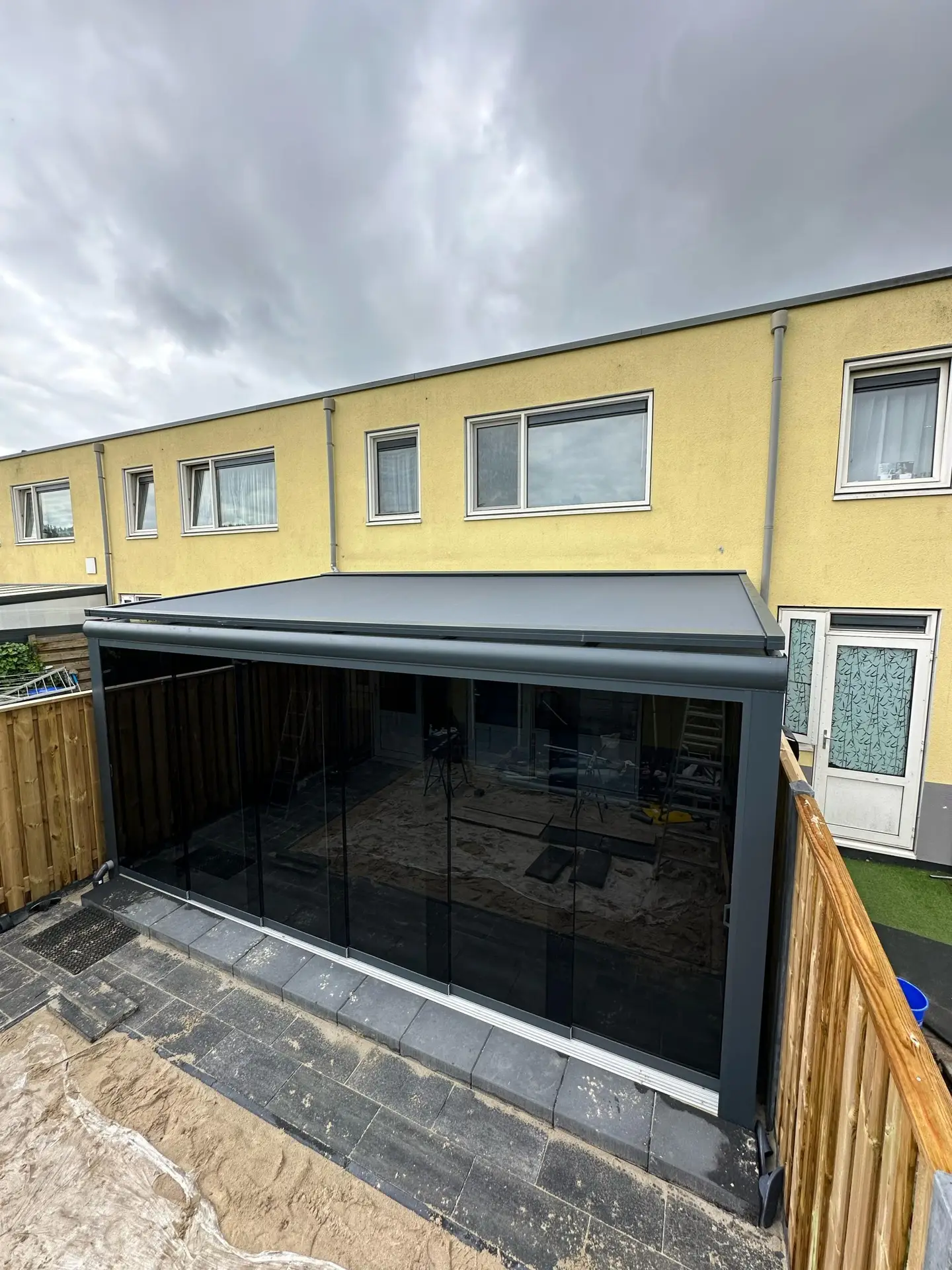 Moderne LuxLine Terrassenüberdachung in Schwarz mit komplettem Glasrundumschutz