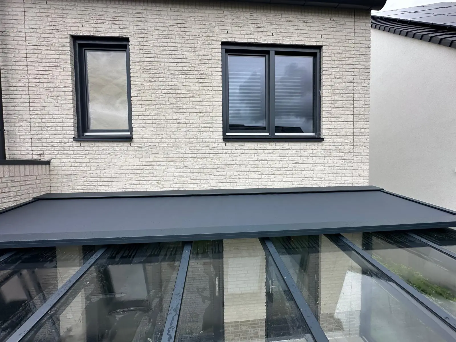 Terrassenüberdachung mit integrierter, elektrischer Somfy-Markise auf dem Dach