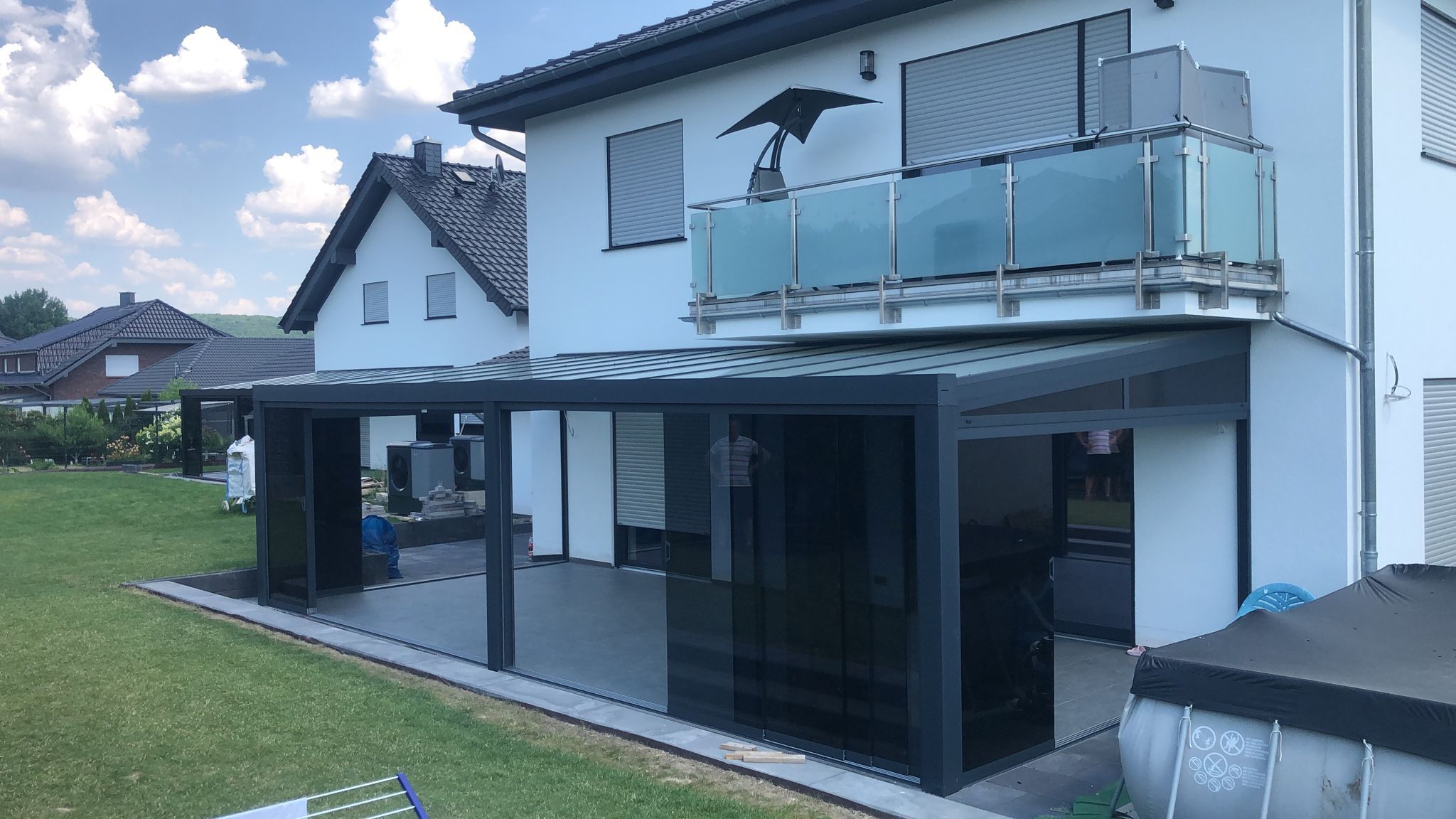 ProLine Terrassenüberdachung mit dunklen Glasschiebewänden und dunklem Glaskeil