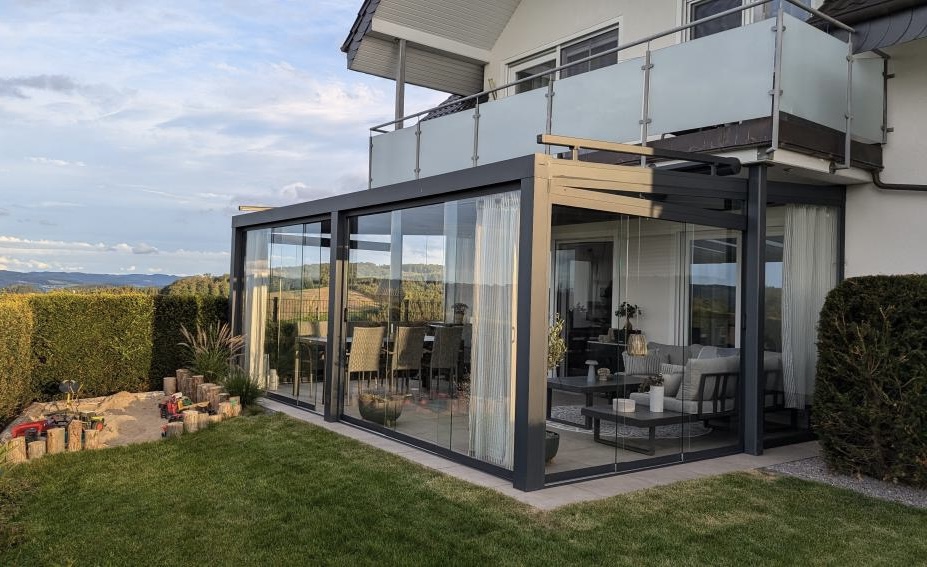 Terrassenüberdachung mit Glasdach und Glasschiebewänden als geschützter Terrassenbereich
